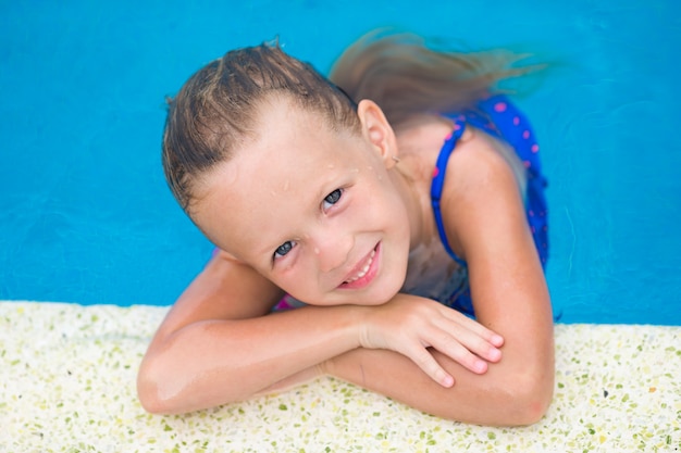 Portrait de sourire jolie fille mignonne dans la piscine extérieure