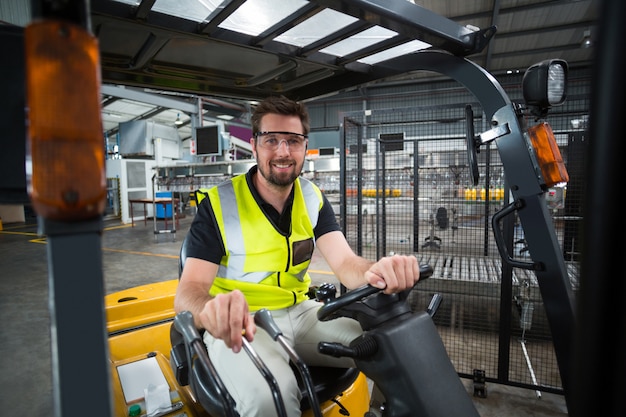 Portrait, de, sourire, ouvrier usine, conduite, chariot élévateur