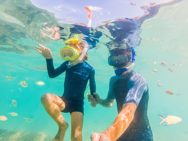 Portrait sous-marin du père et du fils faisant du snorkeling ensemble