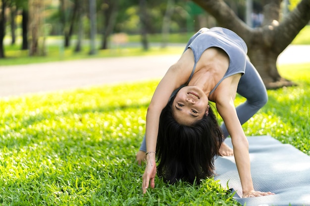 Photo portrait sport asiatique beauté corps mince femme en vêtements de sport assis se détendre et fille pratiquant le yoga et faire des exercices de fitness dans le parc à la maison concept de régimefitness et santé