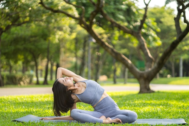 Photo portrait sport asiatique beauté corps mince femme en vêtements de sport assis se détendre et fille pratiquant le yoga et faire des exercices de fitness dans le parc à la maison concept de régimefitness et santé