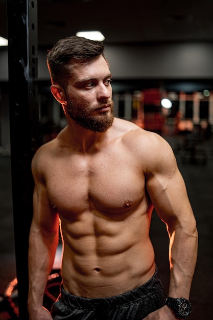 Portrait d'un sportif au corps parfait. Beau mâle avec des muscles et une forte pression. Bodybuilder torse nu.