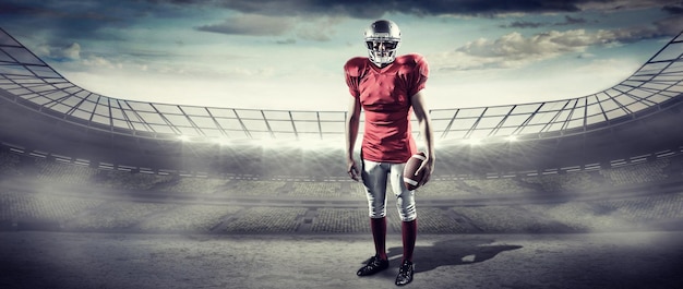 Photo portrait de sportif avec le football américain contre le stade de rugby