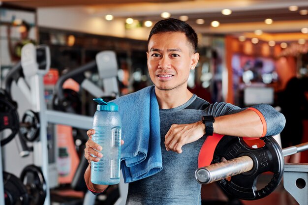 Portrait de sportif avec serviette et bouteille d'eau