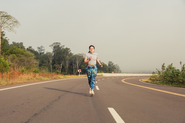 Portrait d'une sportive en cours d'exécution sur la route