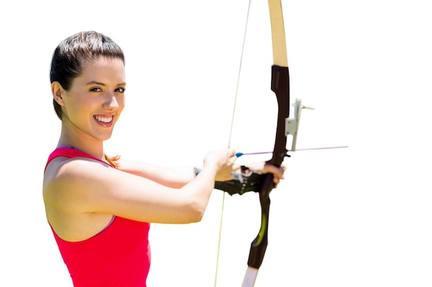 Photo le portrait de la sportive sourit et pratique le tir à l'arc