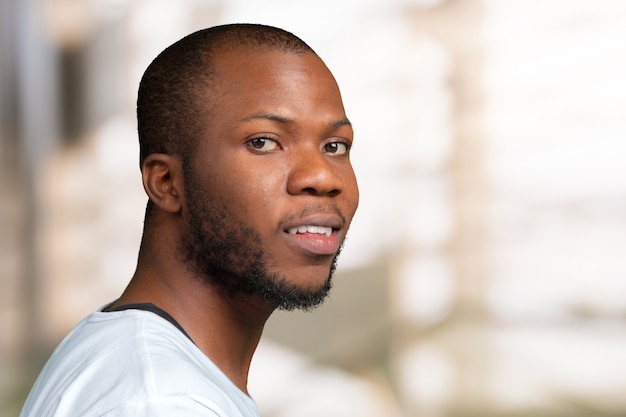 Portrait de Stong et beau étudiant africain mâle, regardant la caméra en souriant