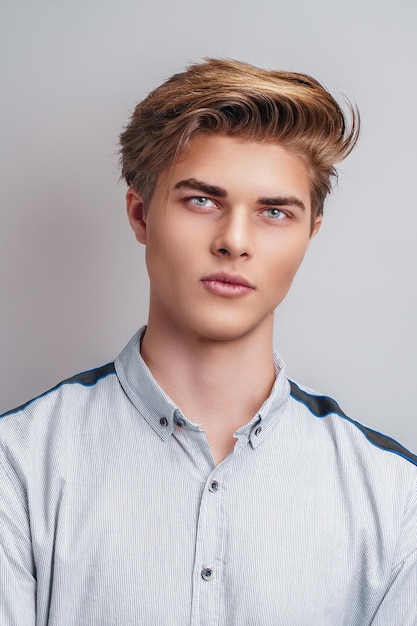 Portrait en studio d'un beau jeune homme caucasien élégant qui regarde le portrait de l'homme de la caméra