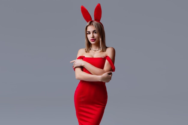 Portrait en studio d'une belle fille en robe rouge et avec des oreilles de lapin