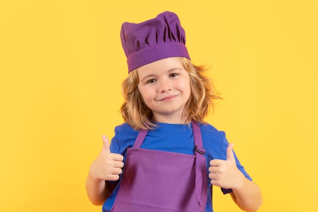 Portrait de studio de cuisinier drôle enfant chef cuisiner enfants chef enfant garçon faisant des aliments sains portrait de petit enfant en toque isolé sur fond de studio