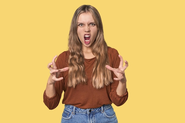 Portrait en studio d'une femme blanche blonde qui crie de rage