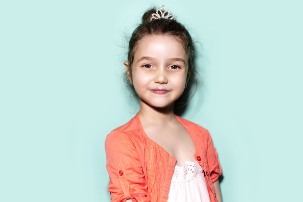 Portrait en studio de fille enfant gaie sur fond de couleur aqua menthe