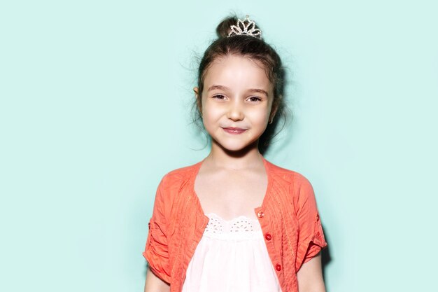 Portrait en studio de fille enfant gaie sur fond de couleur aqua menthe