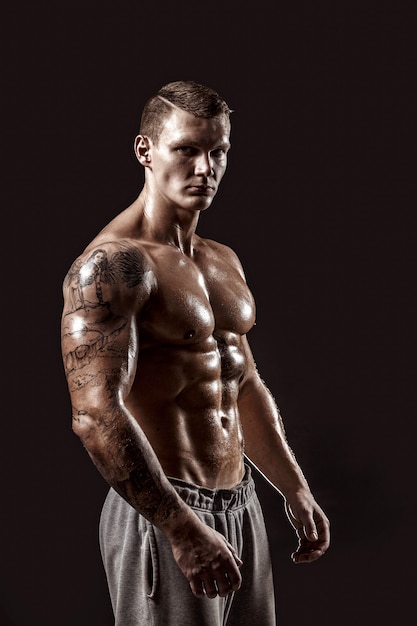 Portrait en studio d'un homme tatoué athlétique torse nu