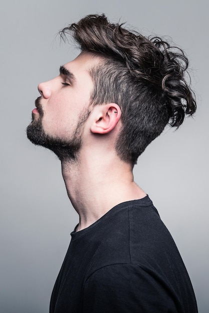 Portrait en studio de jeune bel homme avec une coiffure fashion