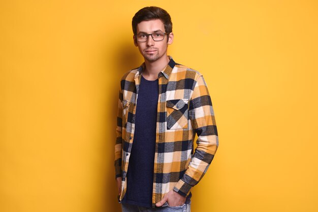 Portrait en studio de jeune bel homme à lunettes posingolated