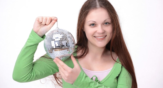 Portrait en studio de jeune femme en robe de soirée tenant une boule disco