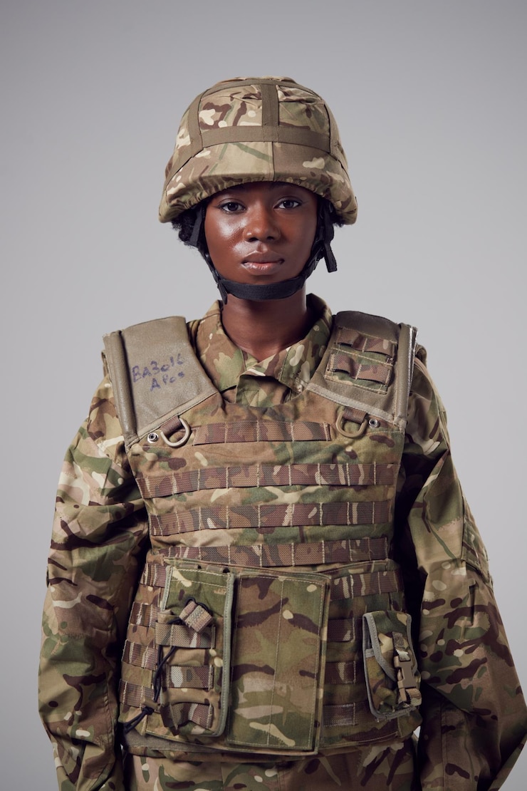 Photo portrait en studio d'une jeune soldat sérieuse en uniforme militaire sur un fond plat