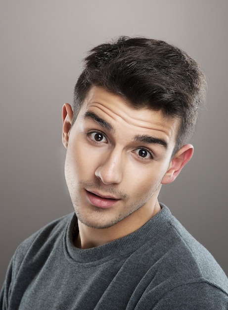 Portrait en studio d'un jeune souriant regardant la caméra