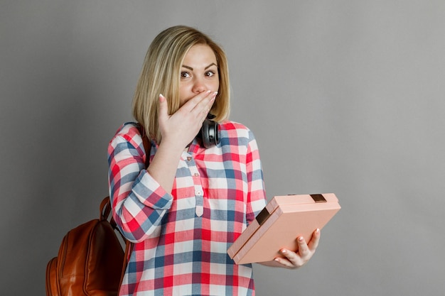 Portrait en studio d'une jolie fille blonde un étudiant dans une chemise à carreaux regardant un cadeau une agréable surprise un cadeau dans une boîte joyeuse jubilation Saint Valentin