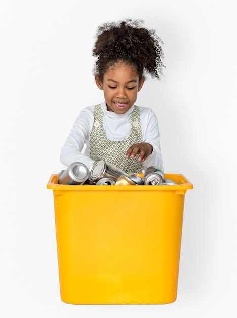 Portrait de studio de petite fille séparant une boîte en métal recyclable
