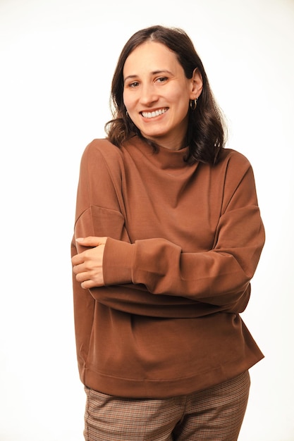 Portrait en studio vertical d'une femme aux bras croisés souriant à la caméra