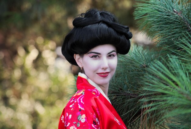 Portrait de style asiatique d'une femme rêveuse en kimono rouge