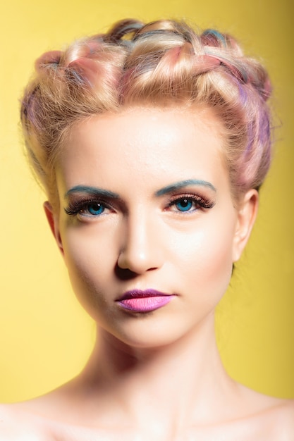 Portrait style pin-up d&#39;une belle jeune femme aux yeux bleus et maquillage. sur fond jaune