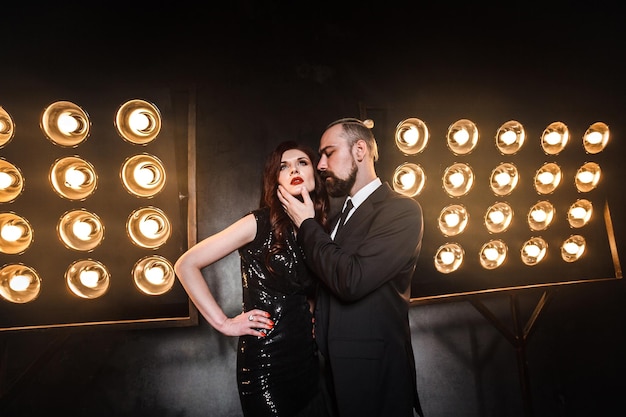 Portrait de style romantique d'un couple élégant dans l'homme d'affaires de boîte de nuit touchant le menton beau