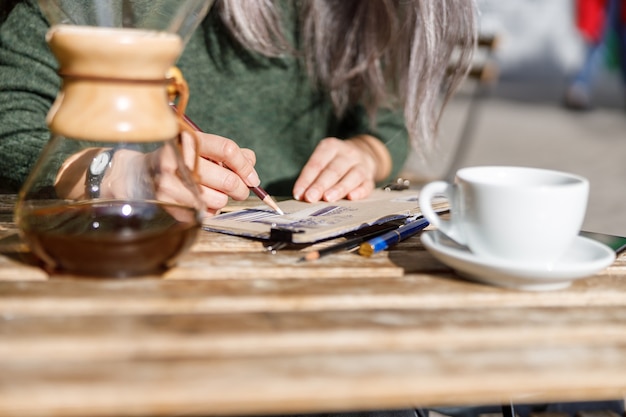 Portrait de style de vie femme élégante cheveux pâles matures à l'extérieur près du café