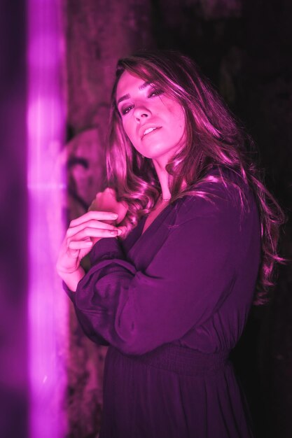 Portrait de style de vie d'une fille caucasienne dans une grotte avec lumière led violette