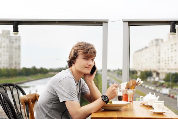 Portrait de style de vie d'un jeune homme utilisant un smartphone à l'extérieur