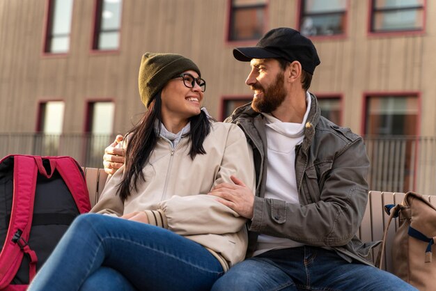 Portrait de taille d'un jeune couple d'amoureux heureux profitant d'un rendez-vous dans la nature. Ils se font des câlins et sourient de bonheur en se regardant