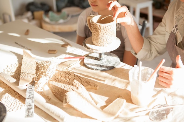 Photo portrait d'une tasse en céramique faite par une femme et un jeune garçon