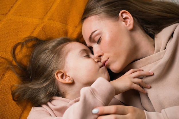 Portrait tendre photo de maman et fille allongée sur le lit