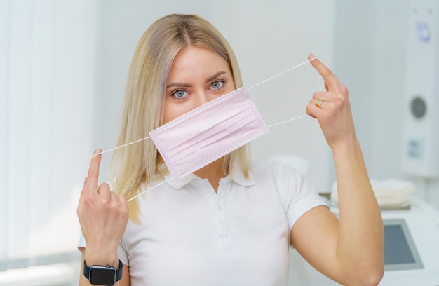 Portrait de la tête et des épaules d'une femme médecin portant un masque de protection et regardant la caméra posant sur fond blanc Espace de copie