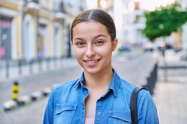 Portrait en tête d'une jeune adolescente positive regardant la caméra