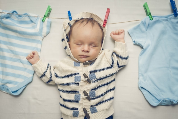 Portrait tonique de petit garçon accroché sur une corde à linge