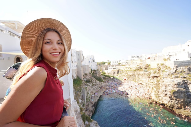 Portrait de touriste girl looking at camera depuis la terrasse à Polignano a mare Pouilles Italie grand angle