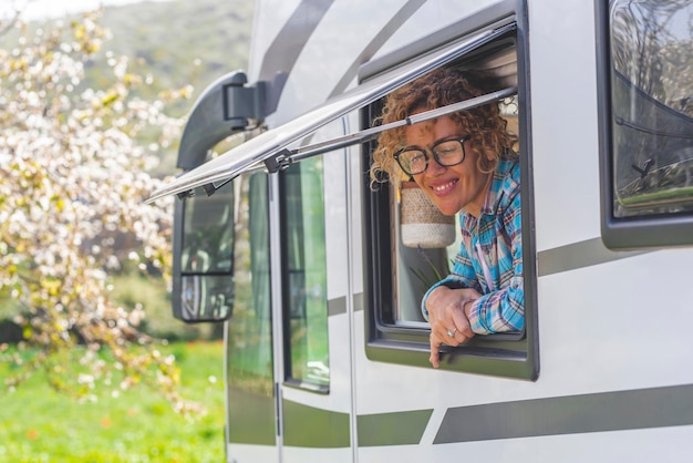 Portrait d'un touriste joyeux profitant d'un parking de destination avec un véhicule de camping-car souriant devant la fenêtre dans un lieu pittoresque de stationnement dans la nature Vanlife et vivant hors réseau Wanderlust Travel