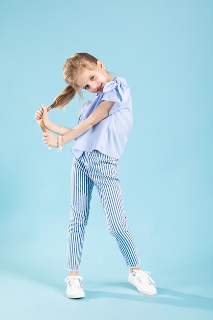 Portrait de toute la longueur d'une belle fille en habits bleus