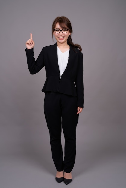 Portrait de toute la longueur de la jeune femme d'affaires asiatique debout
