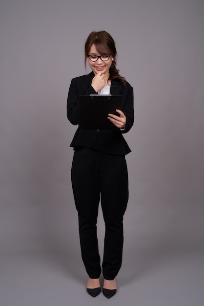 Portrait de toute la longueur de la jeune femme d'affaires asiatique debout