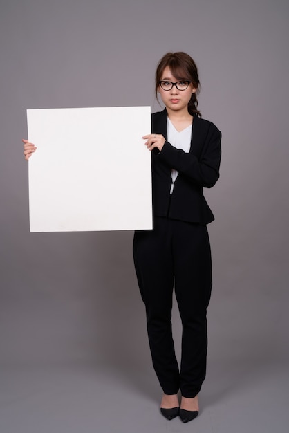 Portrait de toute la longueur de la jeune femme d'affaires asiatique debout