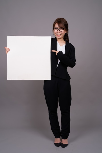 Portrait de toute la longueur de la jeune femme d'affaires asiatique debout