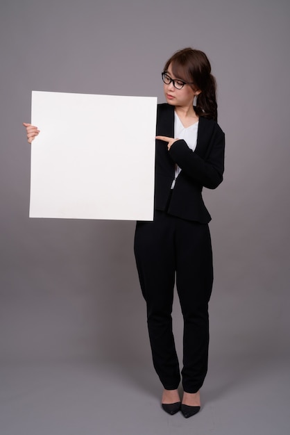 Portrait de toute la longueur de la jeune femme d'affaires asiatique debout