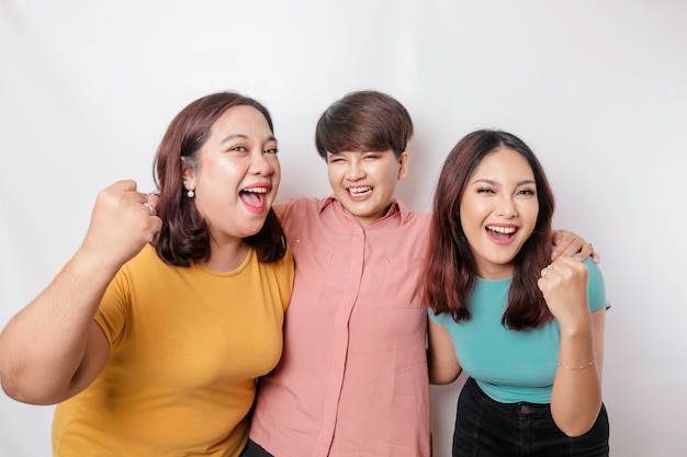 Un portrait de trois amis avec une expression heureuse et réussie isolée par un fond blanc