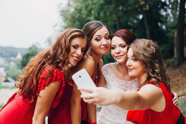 Portrait de trois belles demoiselles d'honneur en robe rouge