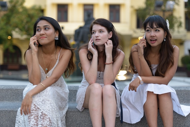 Portrait de trois belles jeunes femmes multiethniques comme amis ensemble dans le parc en plein air