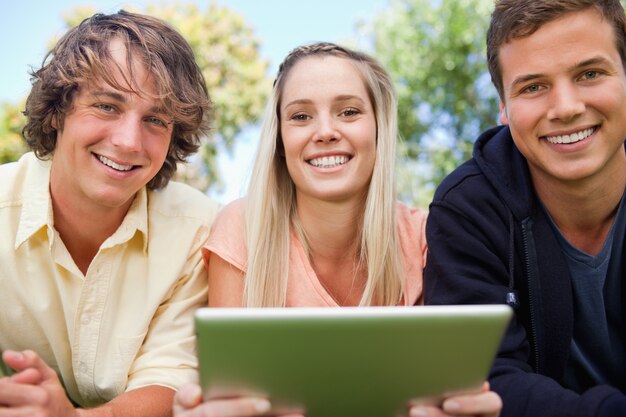 Portrait de trois étudiants utilisant une tablette tactile